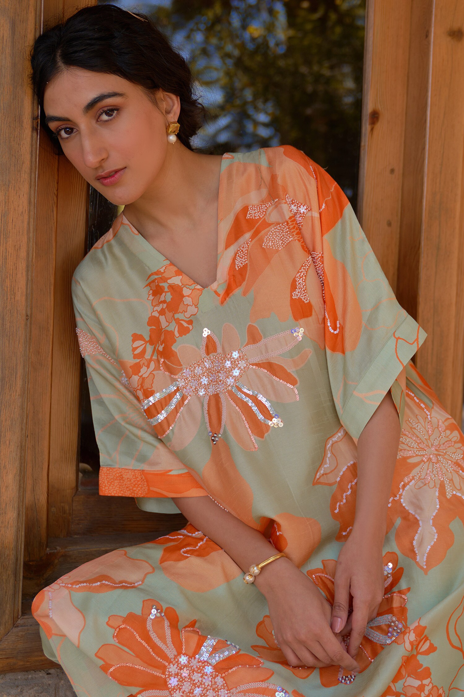 Green and orange floral embroidered tunic with V-neck sequins and matching colorblocked orange pants.